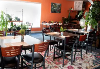 The inside of restaurant, Taste of Siam, with a few tables and orange walls