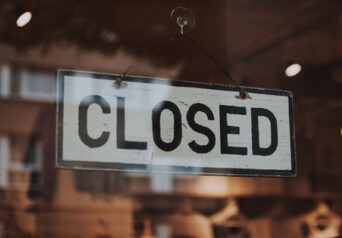 A "closed" sign on the door of a business