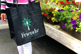 Friends' Marketplace tote bag in front of flowers