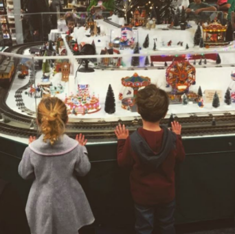 Two kids watching a winter train display at Snow's