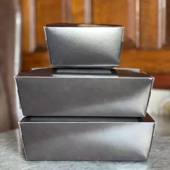 A stack of three silver takeout containers