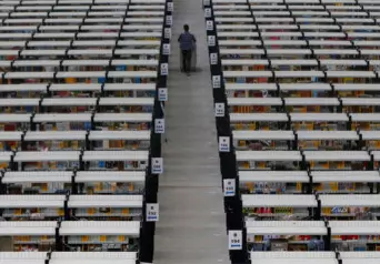 An employee walking down an aisle in an Amazon warehouse