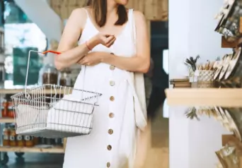 A woman in a white dress shopping in a local boutique