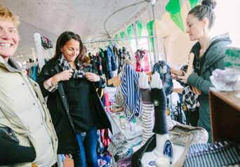 Three people shopping at a local shop with smiles