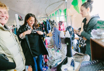 Three people shopping at a local shop with smiles