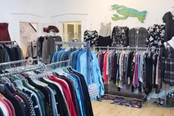 View inside a second-hand shop with racks of clothing