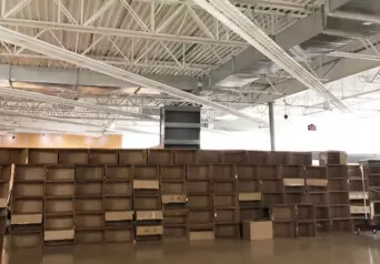 A warehouse with a long wall of stacked cardboard boxes